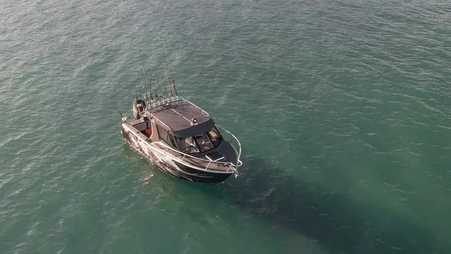 Aerial view of the Kingfisher 705 with shark artwork visible through the water's shadow