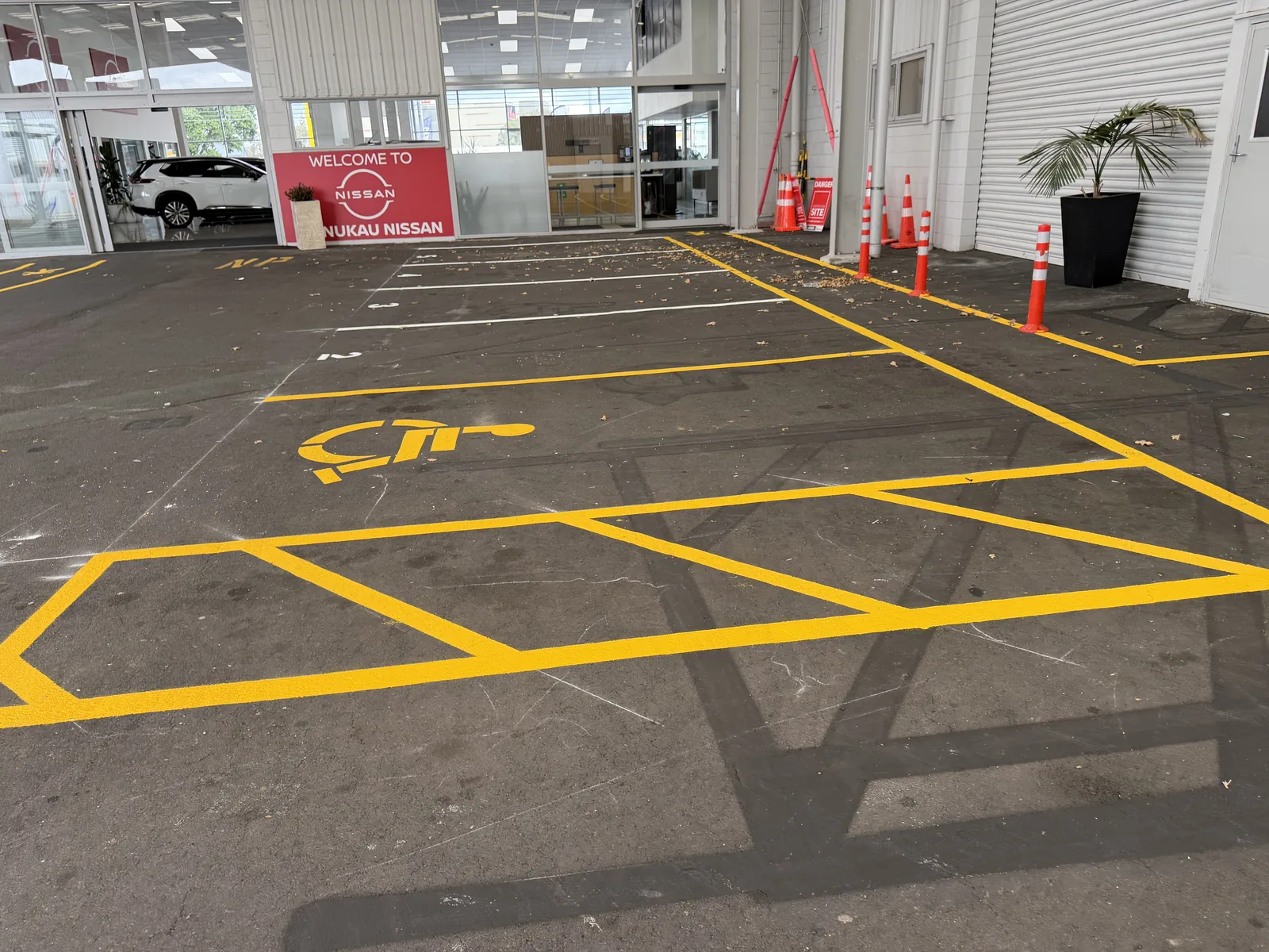 Nissan Manukau dealership carpark with new yellow accessible parking and safety line marking by AAA Signs